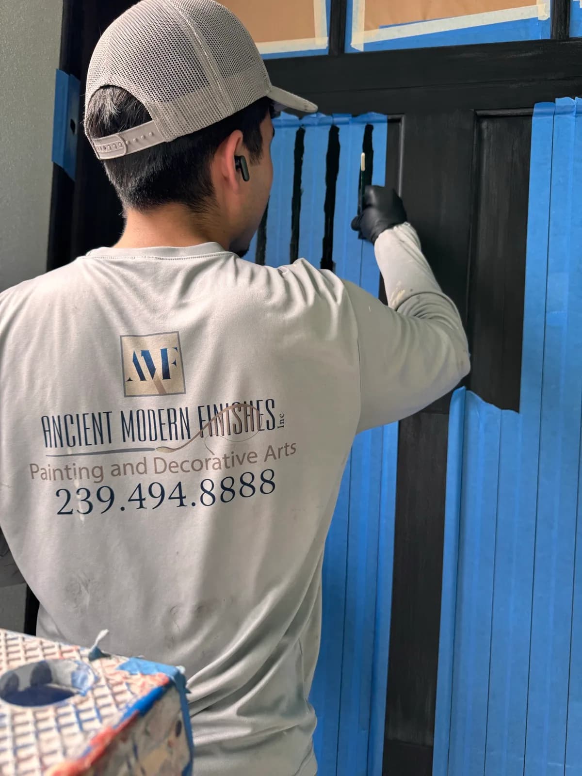 Crew member cutting in the edge of a garage door by hand