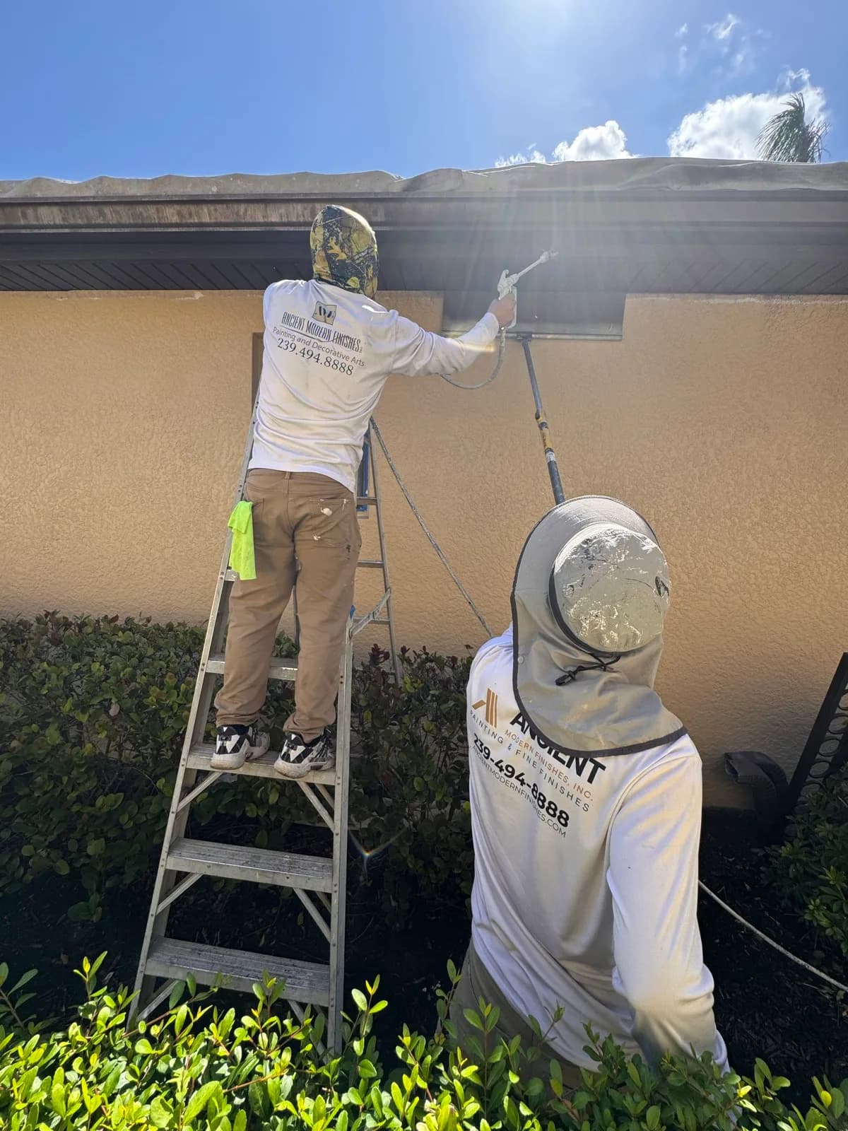 Crew member spraying the underside of the eaves