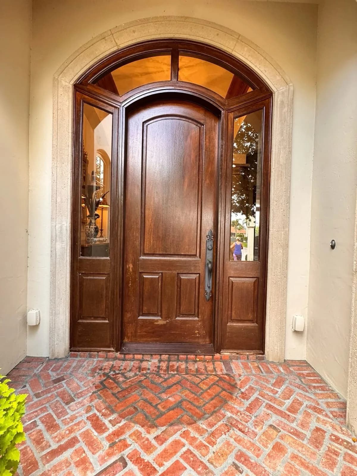 Mahogany double entry doors above a brick step