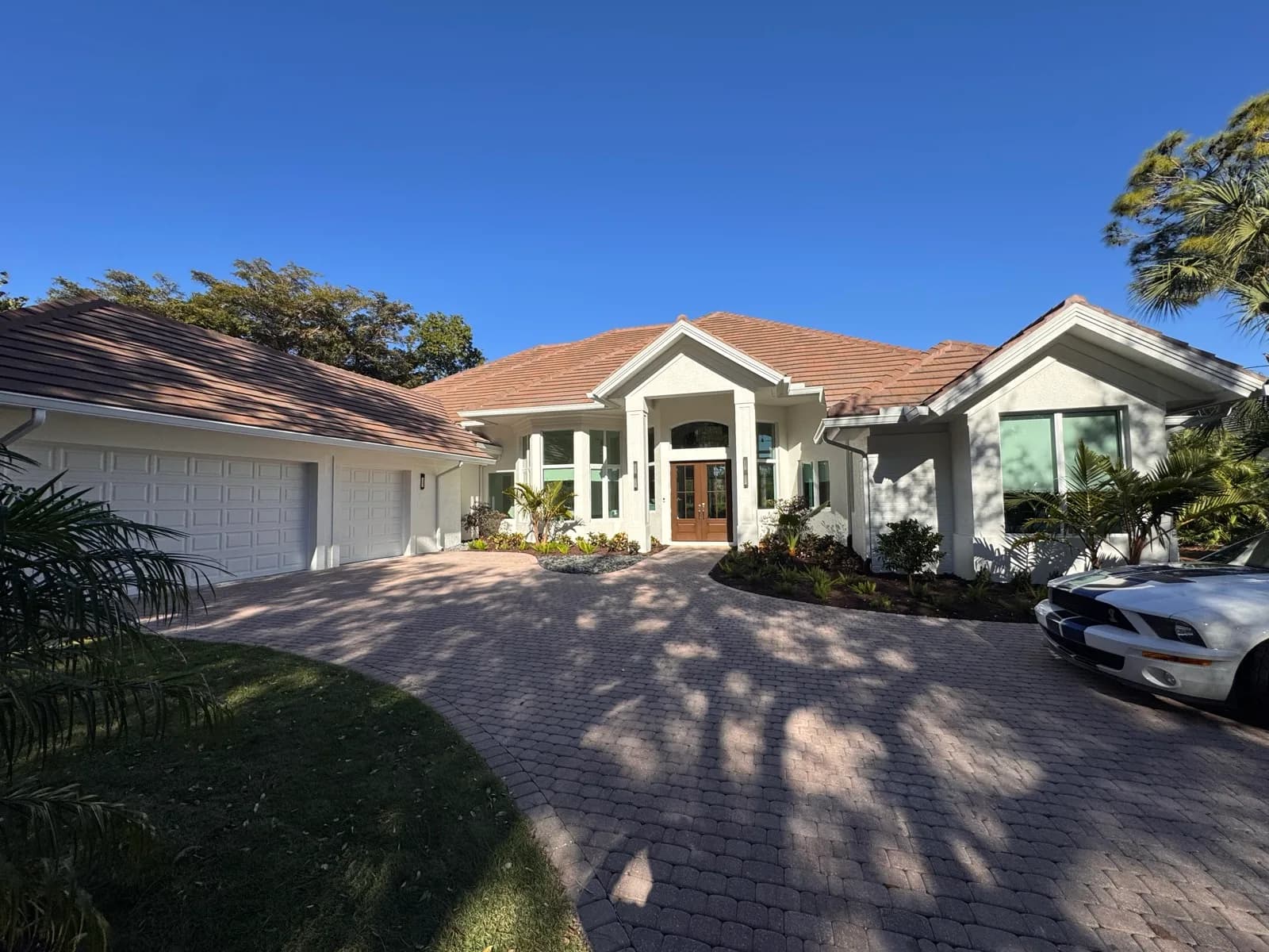 White stucco home with a tile roof after repainting