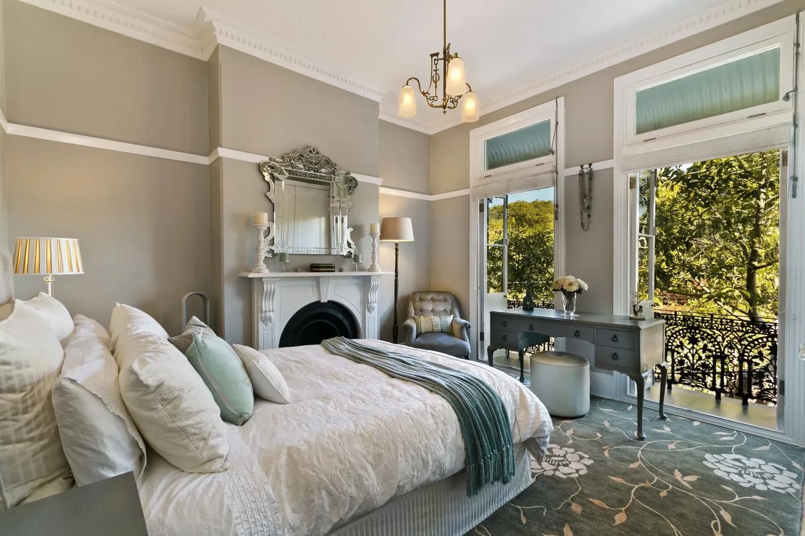 Bedroom with repainted walls, crown moulding and a mirrored fireplace